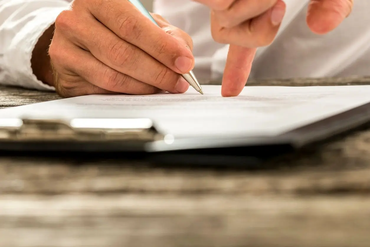 Closeup of male hand pointing where to sign a contract